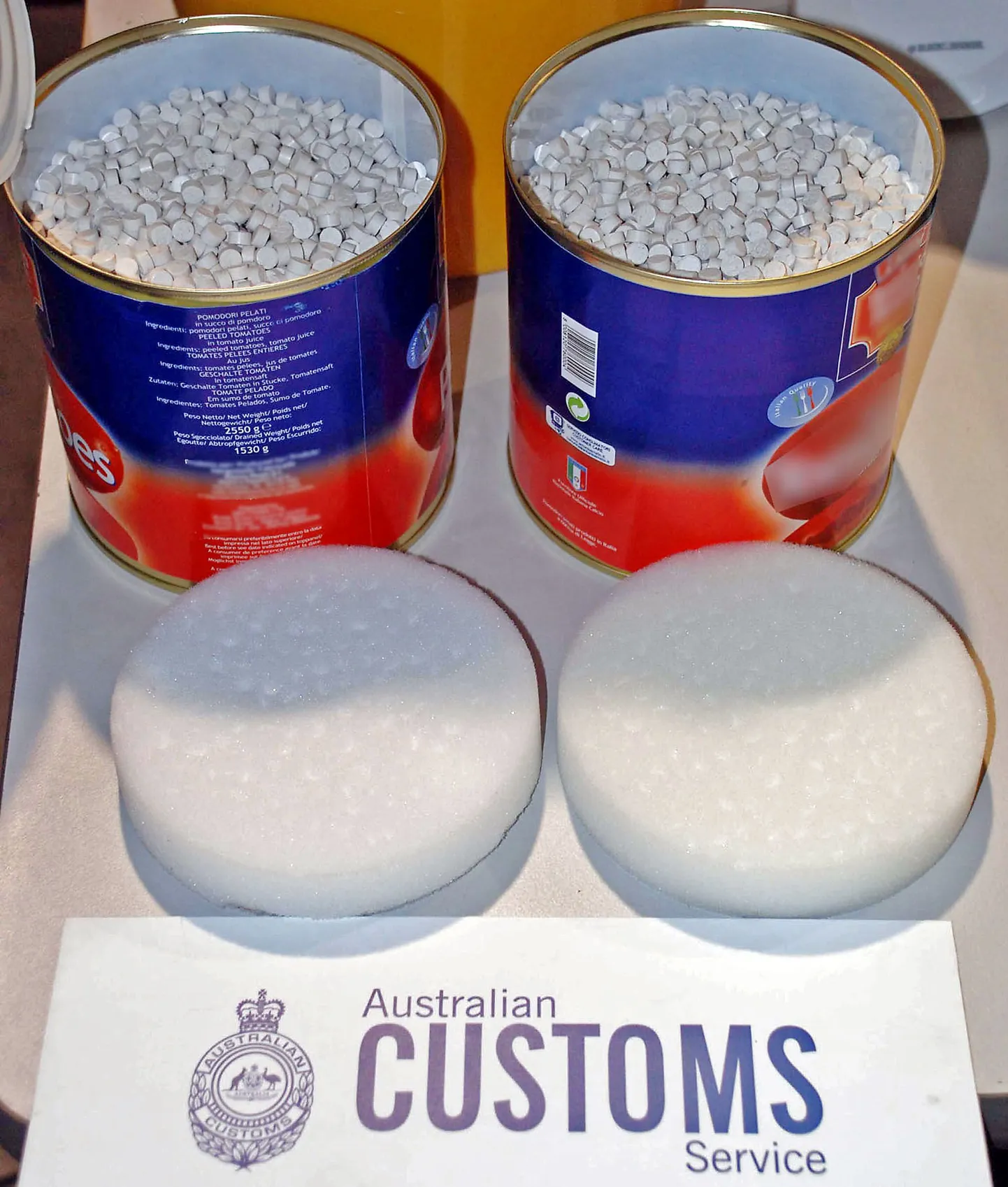 Australian Customs display some of the seized 4.4 tonnes of ecstasy (MDMA) tablets, in what they said was the biggest haul of the illicit drug anywhere in the world, in Melbourne on August  8, 2008. Australian Federal Police Commissioner Mick Keelty said the seizure of the drugs, which were concealed in tins of tomato shipped to Australia from Italy, had resulted in the arrests of 16 people across the country in pre-dawn raids.  AFP PHOTO/Torsten BLACKWOOD