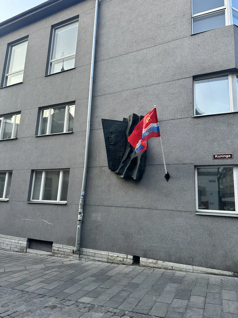 Флаг Эстонской ССР рядом с барельефом Юхана Смуула.