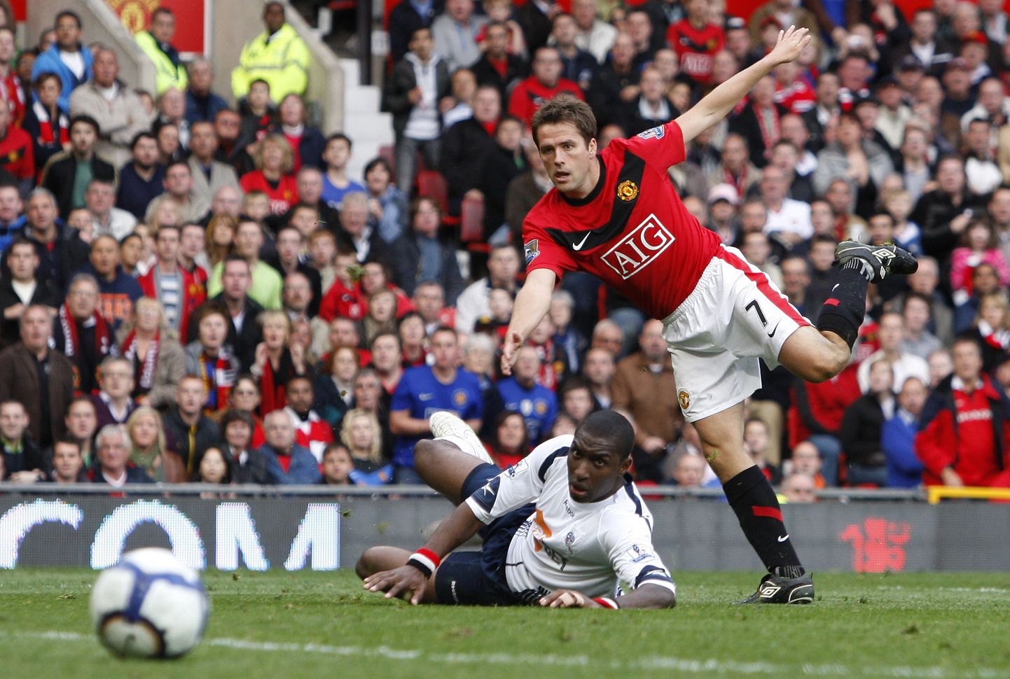 Jlloyd Samuel (valges, pikali) üritab Boltoni värvides takistada Manchester Unitedi  Michael Owenit (paremal). Aasta oli siis 2009.