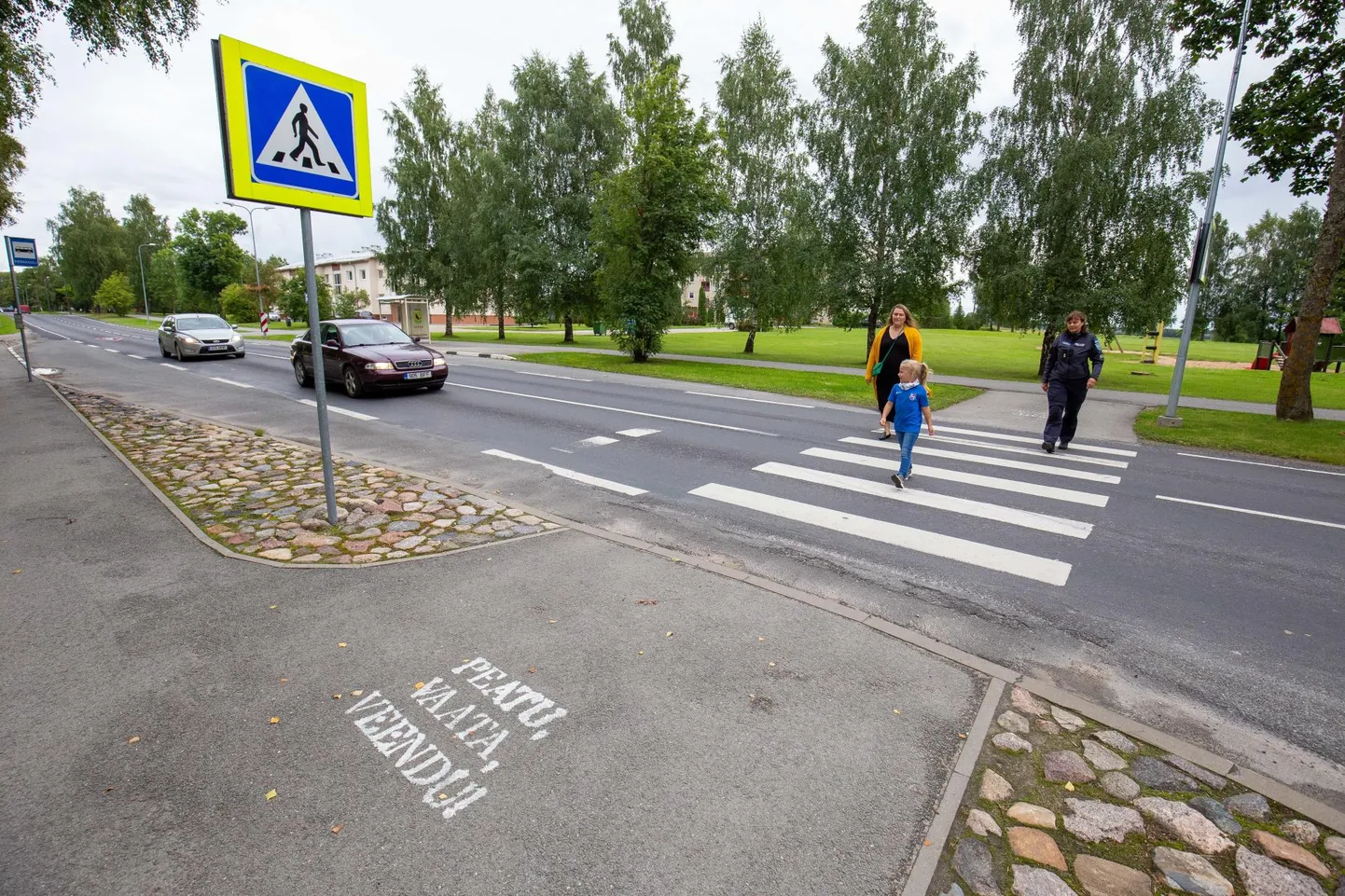 Esimese klassi õpilane Kristiine teab, et ülekäigurajal tuleb tähelepanelik olla. Tema järel tulevad üle tee ema Kirsika Ilmajärv (vasakul) ja noorsoo­politseinik Malle Hermanson.