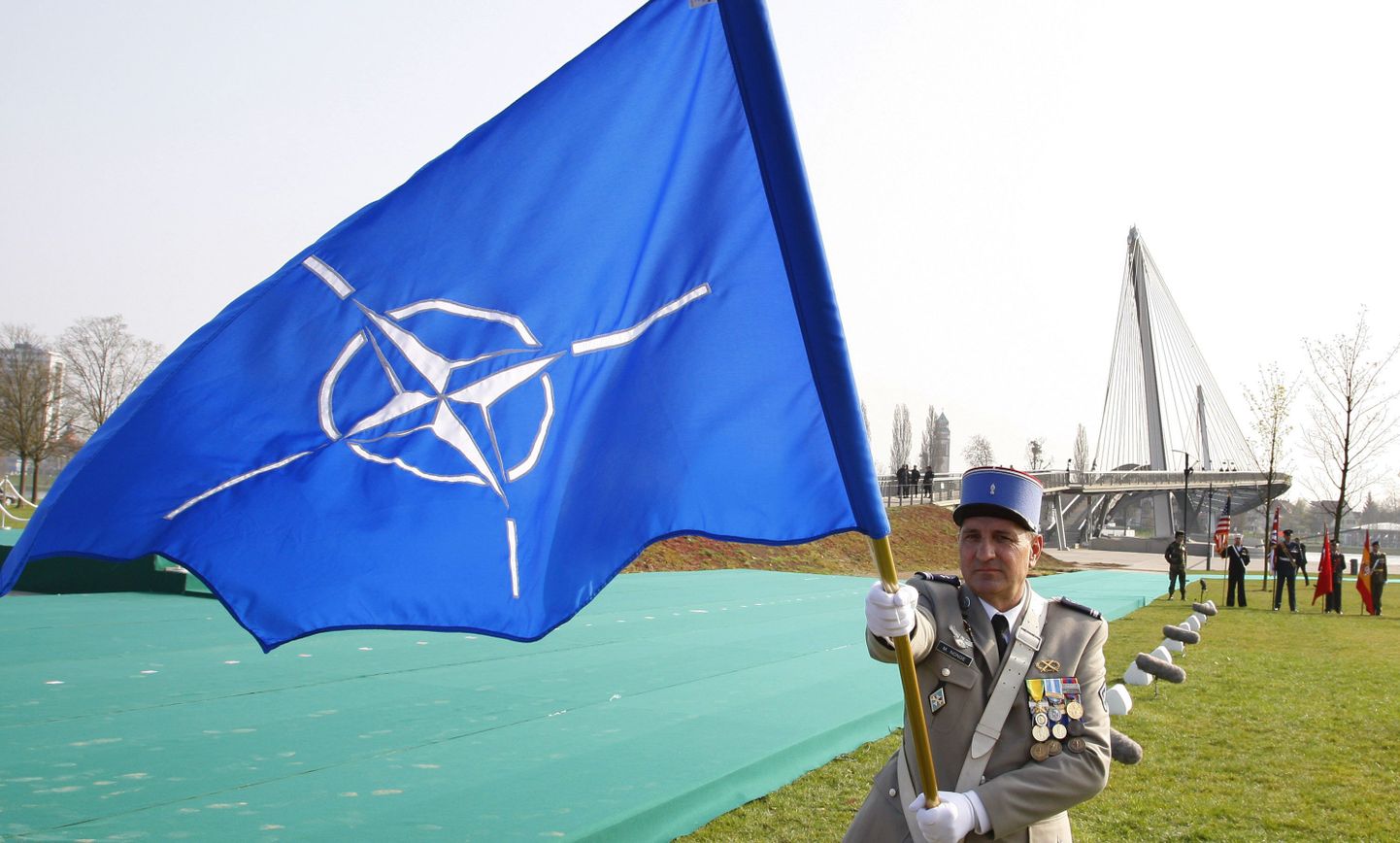 Sõjaväelane NATO lipuga Strasbourgis.