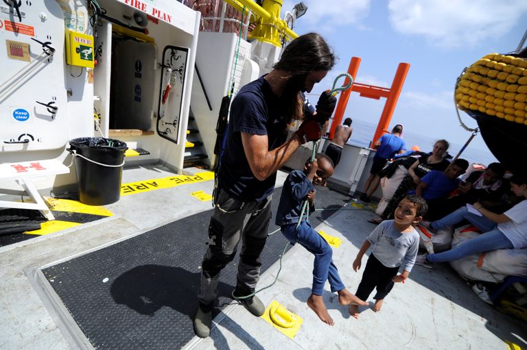 Laeva meeskonnaliige mängimas eile Aquariuse pardal Vahemerelt päästetud lastega.