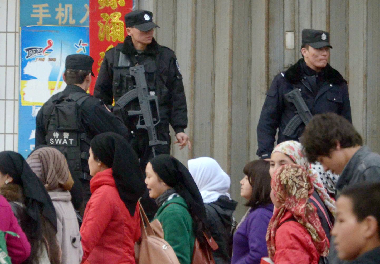 Uiguurid möödumas Hiina politseinikest Xinjiangi Uiguuri autonoomses piirkonnas