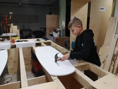 Aloha Veespordikooli õpilane Kristjan Ojaste kinnitab surfikelgu külge mastijala kinnituskruvisid