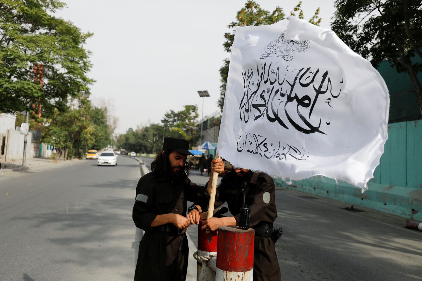 Talibani võitlejad paigaldavad Kabulis asuvasse kontrollpunkti Talibani lipu.