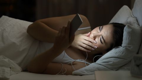 Worried woman watching bad content in a smat phone in the night Worried woman watching bad content in a smat phone in the night