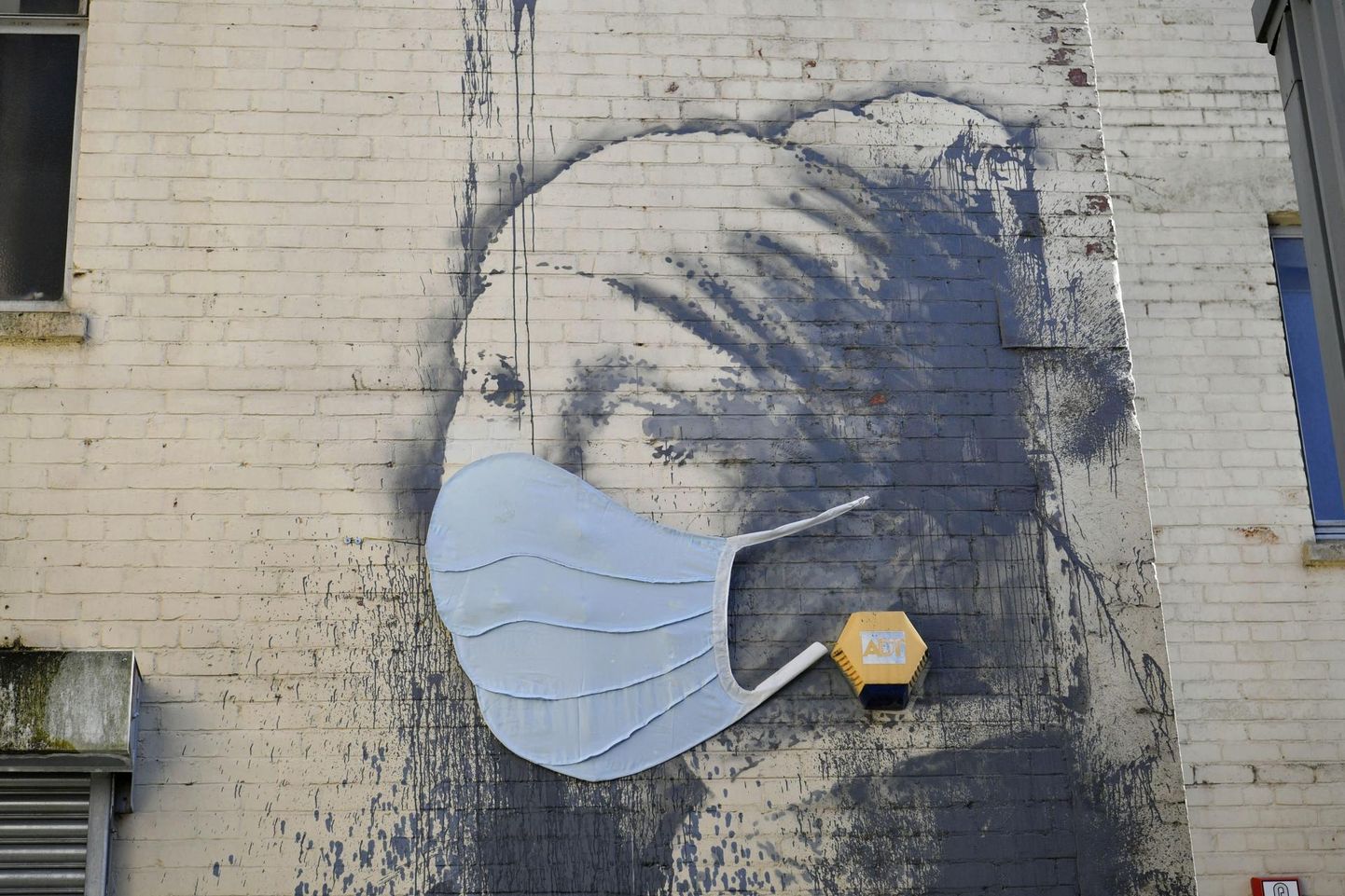 Banksy joonistus Berliinis kannab koroonaajale kohast maski.
