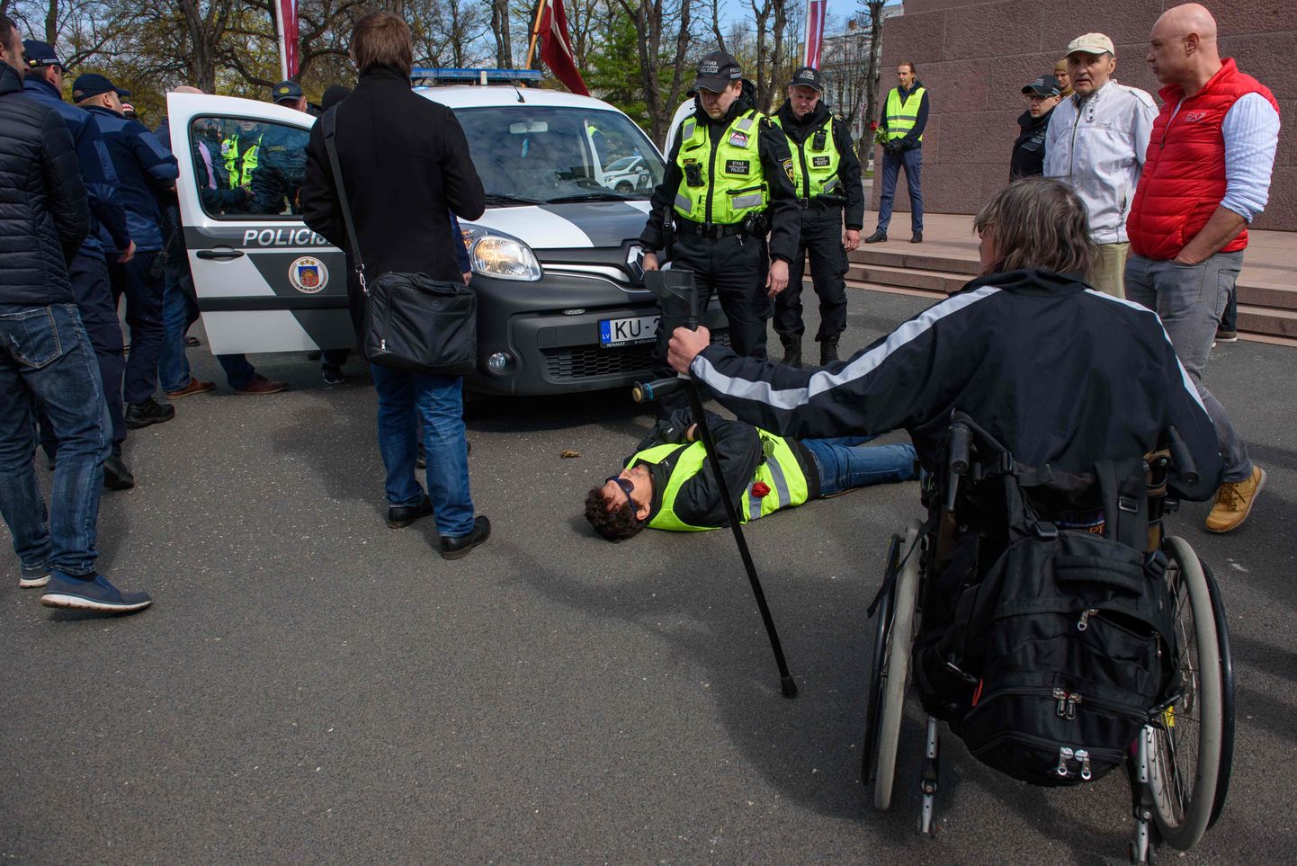 Eriolukorra vastase protesti juhtfiguur, endine telesaatejuht Roberts Klimovičs lebamas  politseiauto ees, enne kui politsei ta kinni võttis.