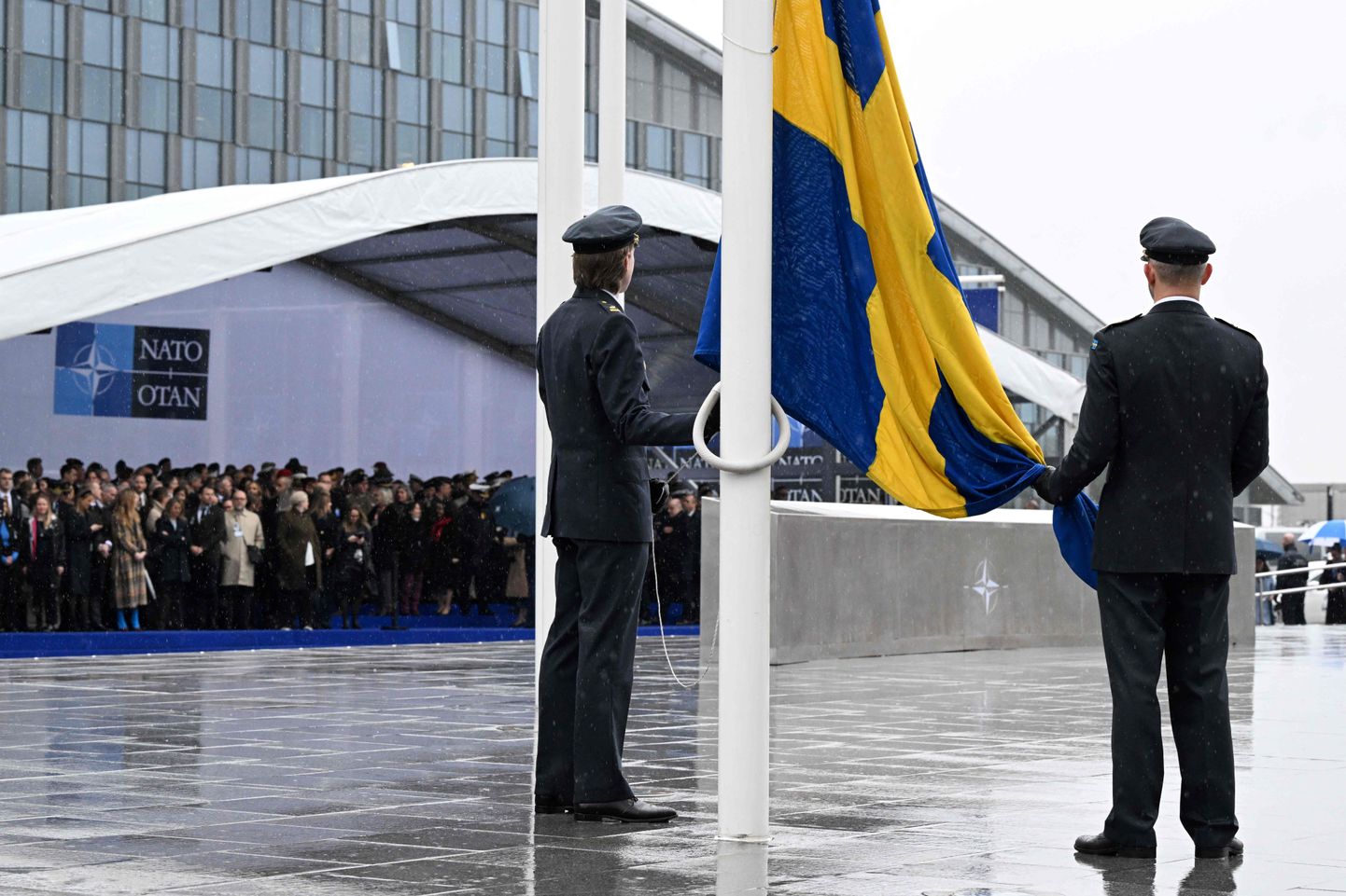 Официальные лица готовятся к поднятию флага Швеции во время церемонии вступления Швеции в НАТО в штаб-квартире Организации Североатлантического договора в Брюсселе 11 марта 2024 года.