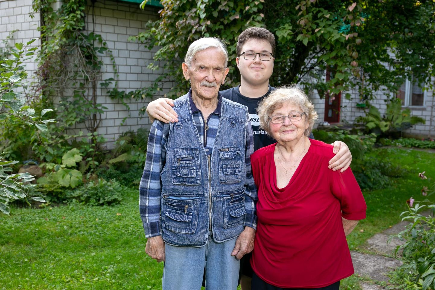 Häädemeeste keskkooli abiturient Marko Lõhmus on koduaias haardesse võtnud vanaema Helgi ja vanaisa Heinar Lõhmuse.