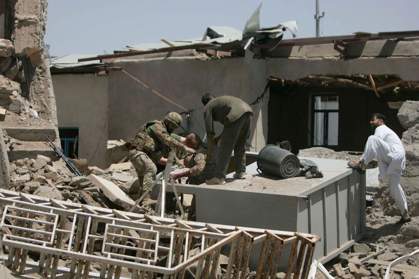 Itaalia sõdurid aitamas plahvatuspaigas kaasvõitlejat.