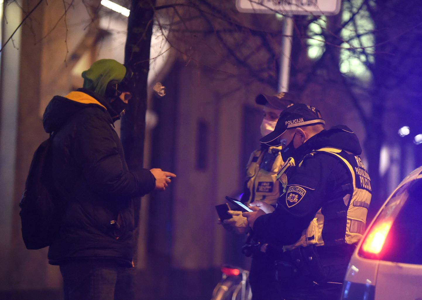 Rīgas pašvaldības policijas darbinieki reida laikā kontrolē, kā tiek ievēroti jaunie komandantstundas ierobežojumi, kad valstī izsludināta ārkārtējā situācija Covid-19 pandēmijas laikā.