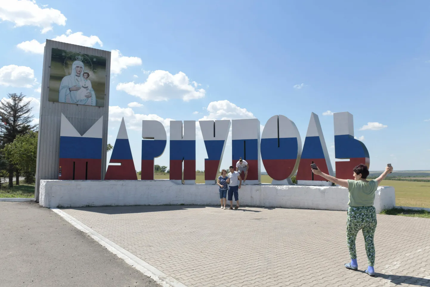 Inimesed poseerivad Vene lipu värvidesse värvitud Mariupoli linna sildi ees
