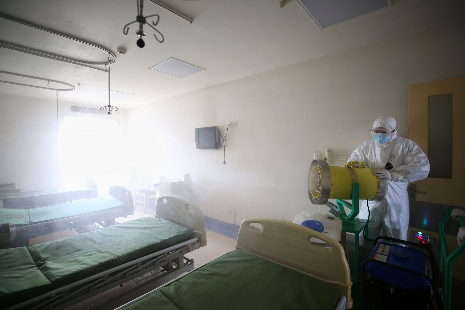 Medicīnas darbinieks dezinficē palātu Uhaņā, Ķīnā