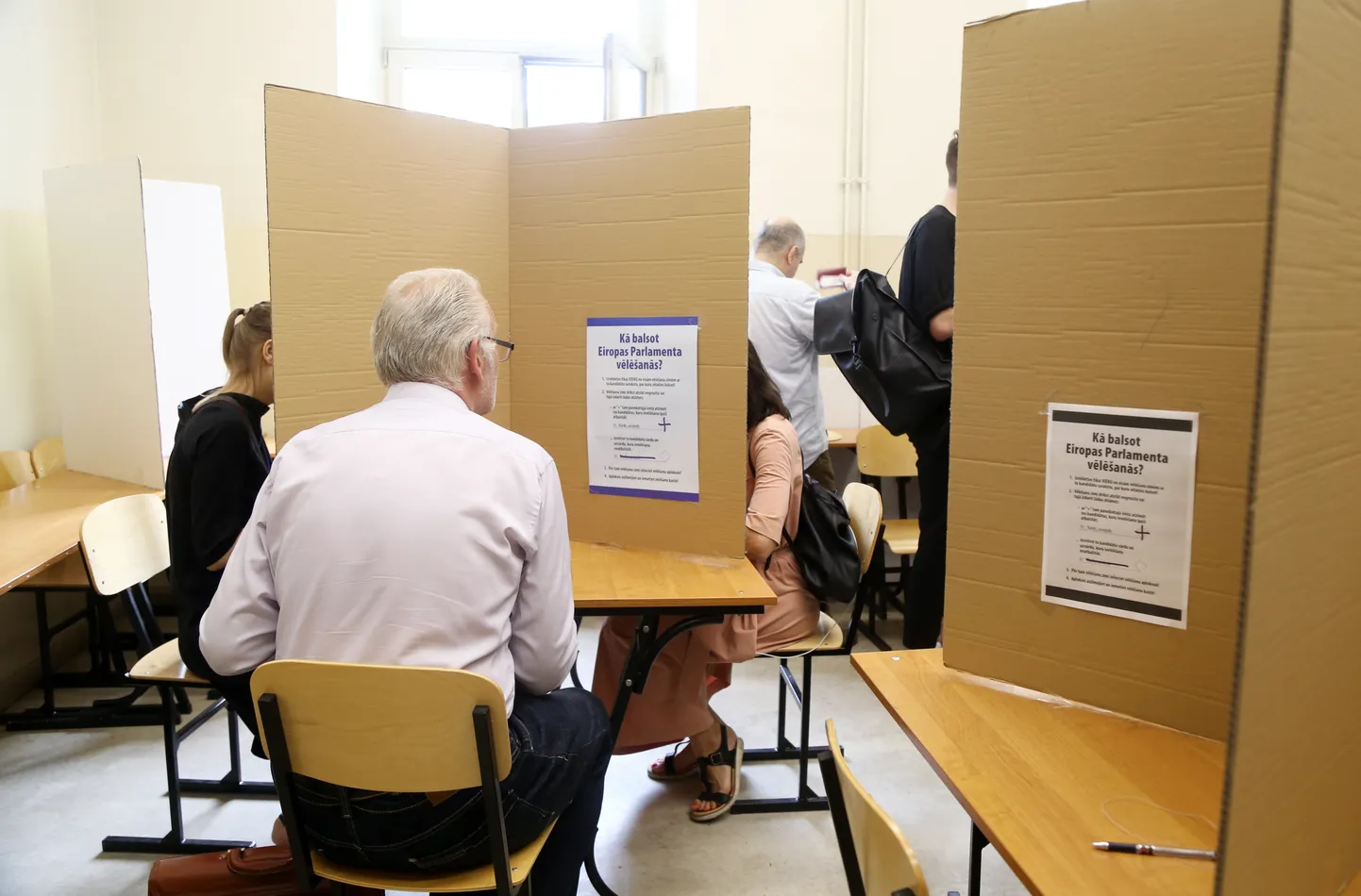 Cilvēki ieradušies nodot savas balsis iepriekšējā balsošanā Eiropas Parlamenta vēlēšanās 3.vēlēšanu iecirknī Rīgas Valsts 1.ģimnāzijā.