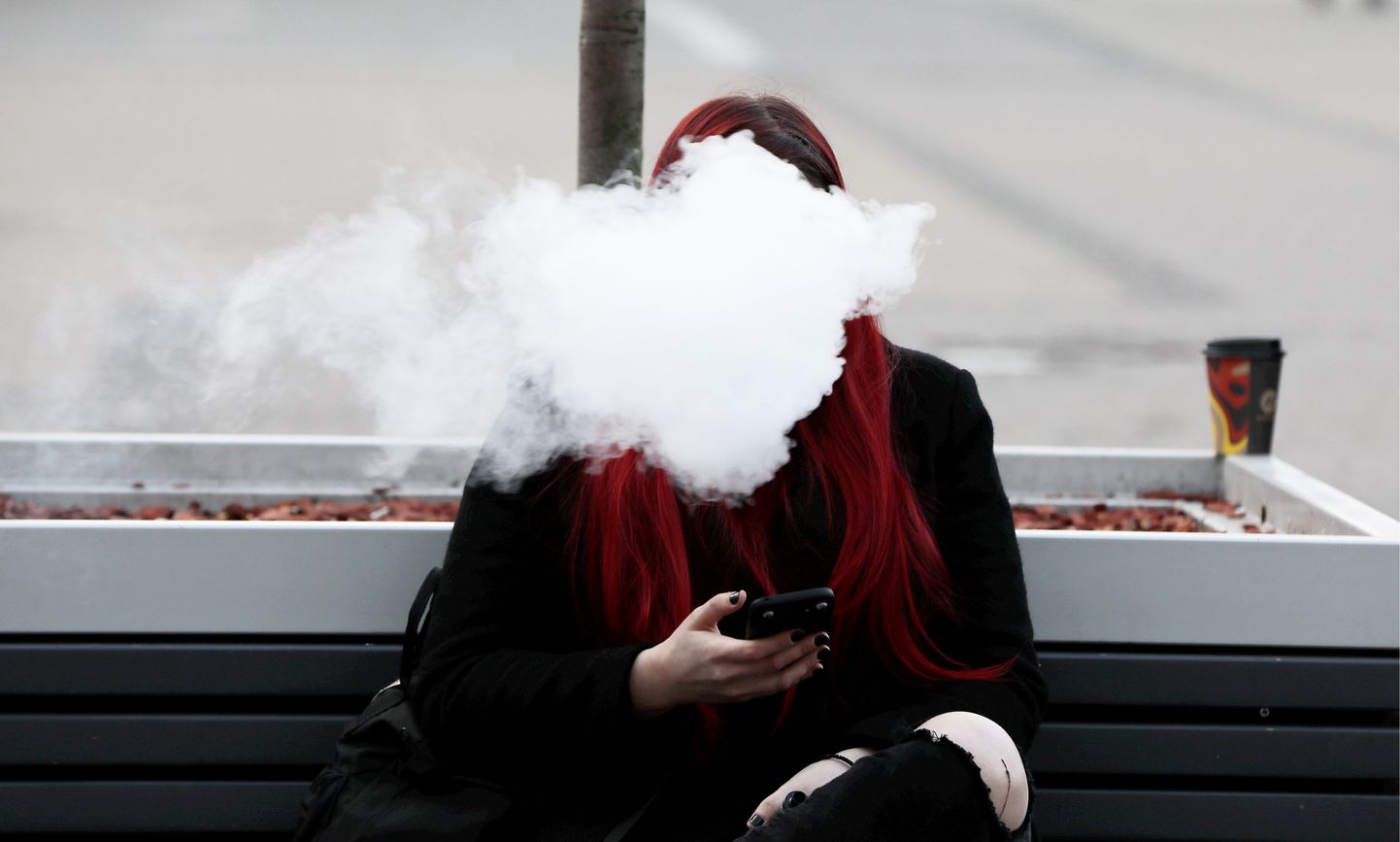 Женщина курит электронную сигарету. Иллюстративное фото