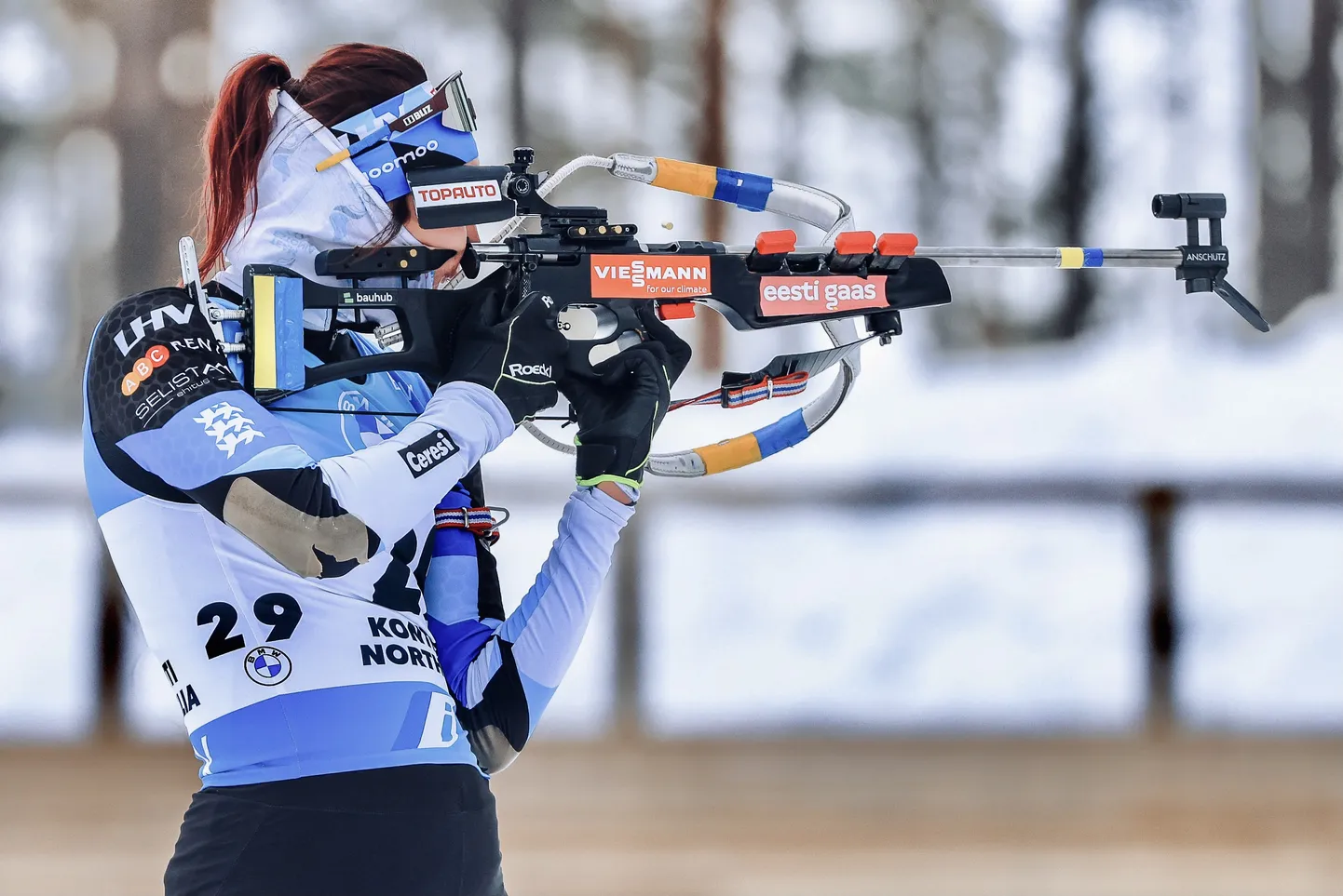Tuuli Tomingas Kontiolahtis märki laskmas, relv ehitud kommipaberitest valmistatud sini-kollase sümboolikaga.