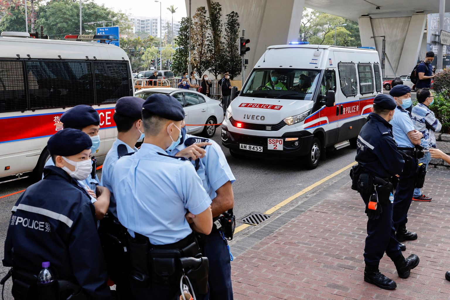 Hongkongi politseinikud demokraatiaaktiviste kohtusse vedavaid väikebusse turvamas.
