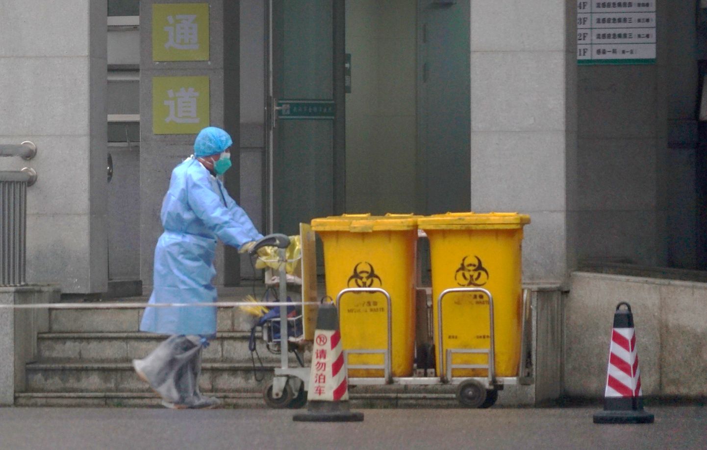 Сотрудники перевозят контейнеры с биологическими отходами в медицинском центре Ухани, где проходят лечение некоторые инфицированные новым вирусом.