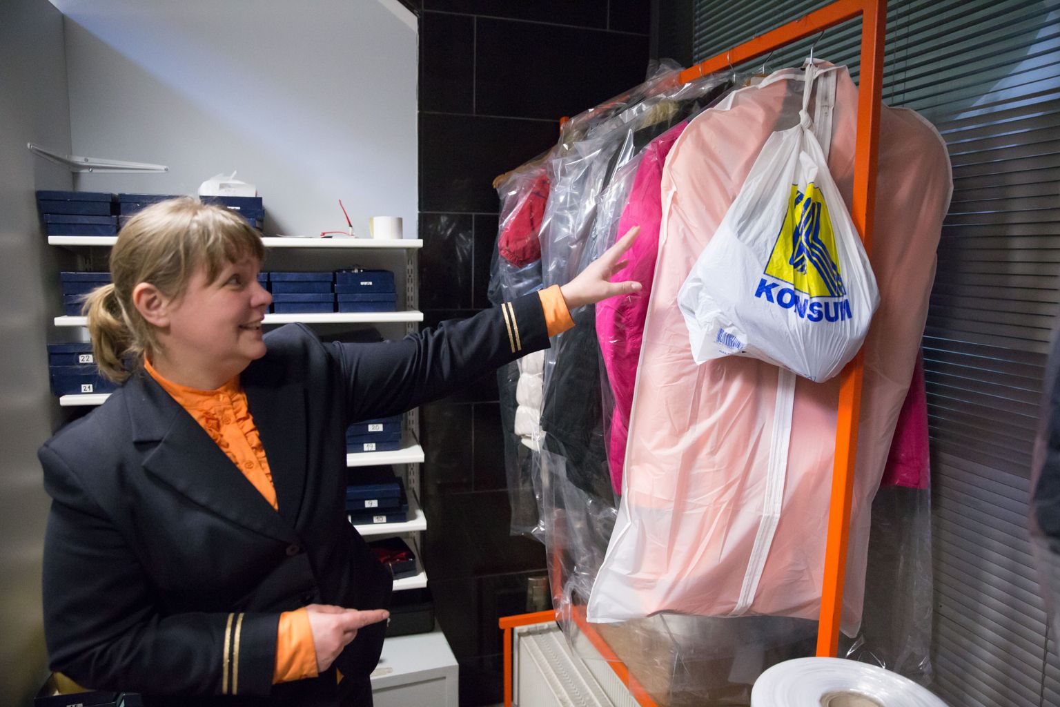Tallinna lennujaama infotöötaja Merje Topkin näitab riidehoidu.