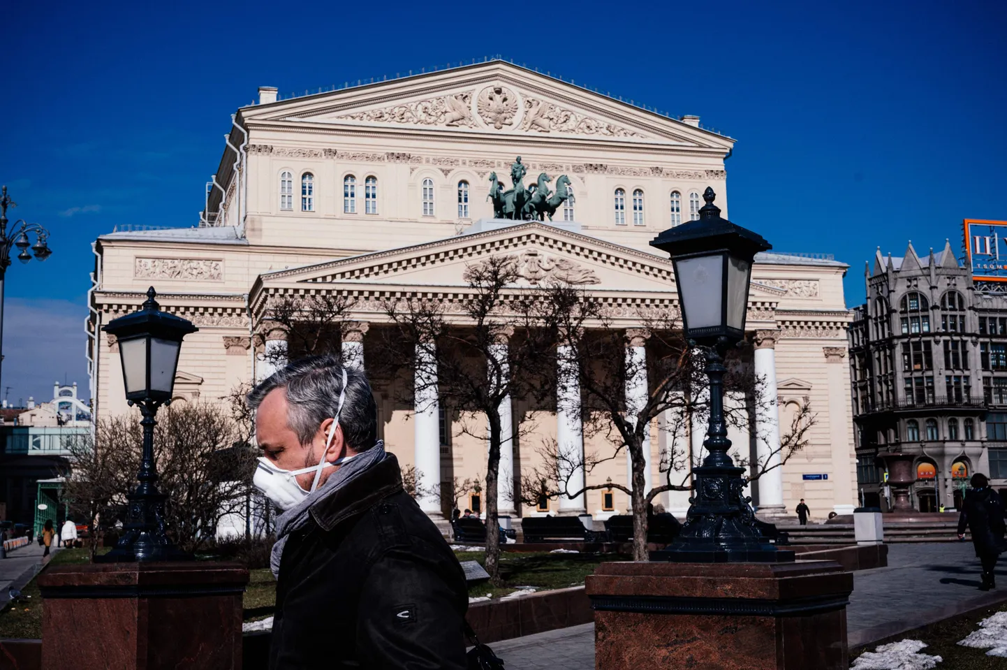 Näomaskis mees Moskva Suure Teatri ees.