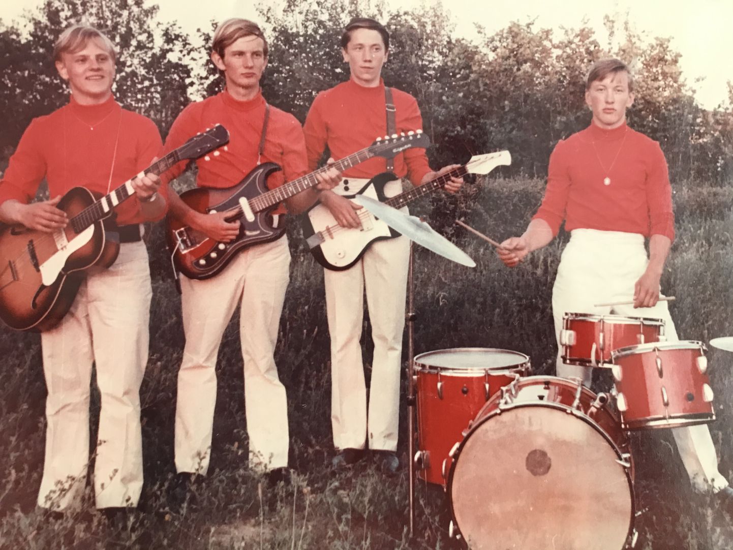 LÕPUPIDU: Bändi liikmed (vasakult) Elmar Sarapik, Uljas Peeters, Tarmo Kask ja Rein Lember 1970. aasta juunis Leisi vana koolimaja juures. Elmaril on Tšehhi päritolu kõlakastiga kitarr Lignatone, Uljasel Tõnu Grepile kuulunud elektrikitarr, Tarmol aga linnapoiste käest ostetud isetehtud bass. Koosseis on Reinu rätsepast isa õmmeldud pükstes, mille juurde kombineeriti punased sviitrid.
