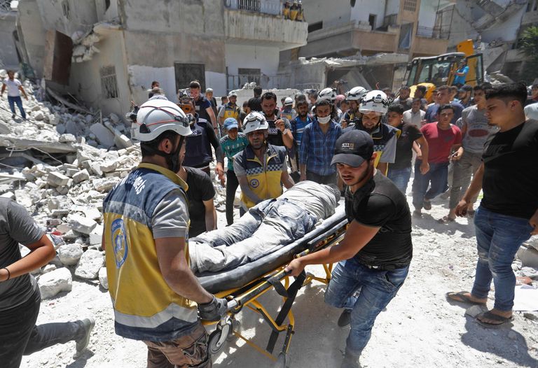 Süüria tsiviilkaitse vabatahtlikud transpordivad Ariha linna õhurünnakus viga saanud inimest kanderaamil.