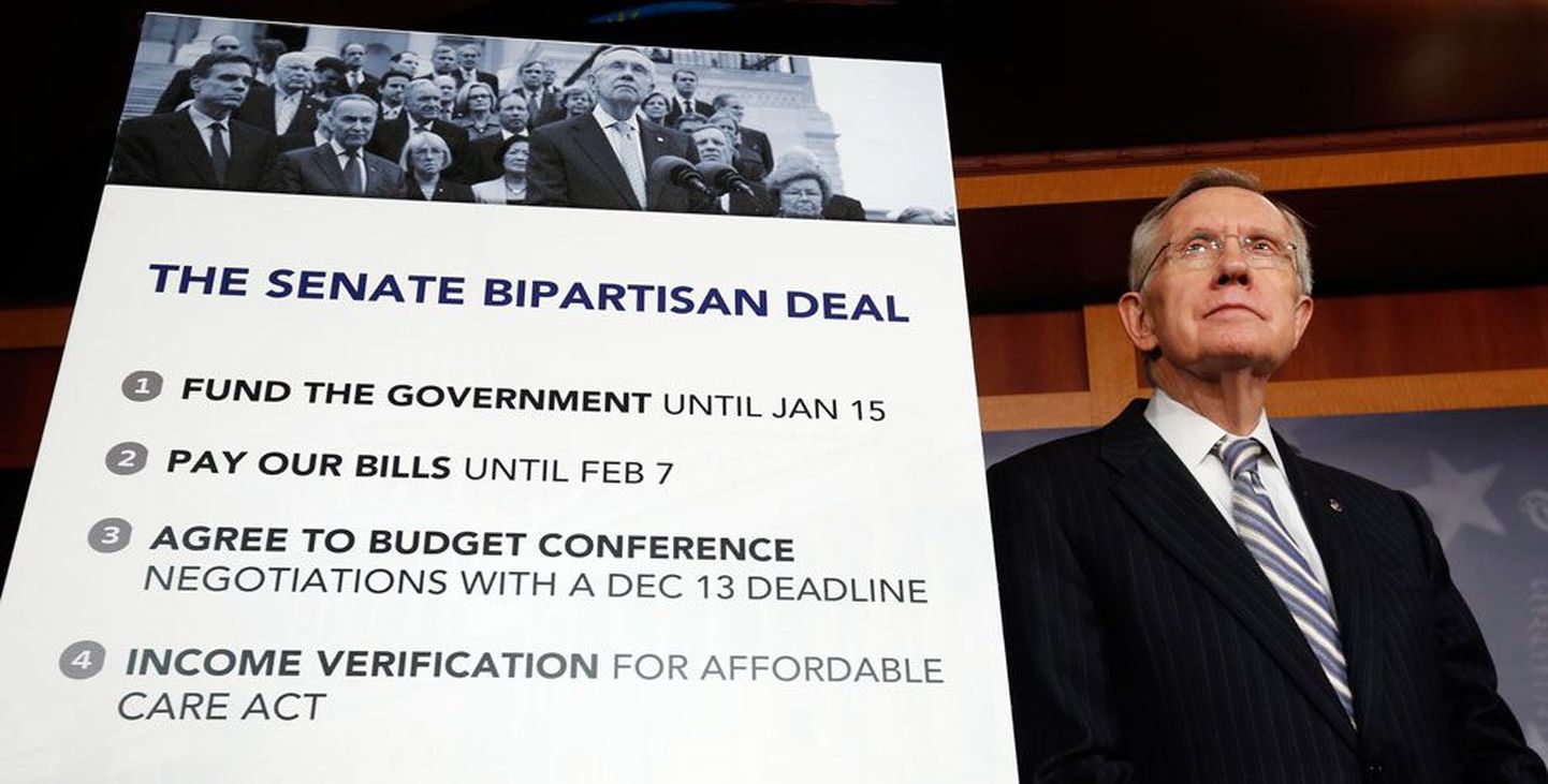 Senati demokraatidest enamuse liider Harry Reid eile seismas kokkulepet tutvustava plakati kõrval.