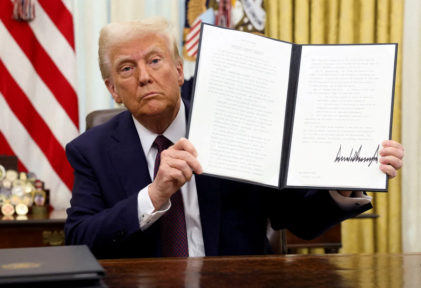 USA president Donald Trump hoiab allkirjastatud täidesaatvat korraldust krüptovaluutade kohta Valge Maja ovaalkabinetis Washingtonis 23. jaanuaril 2025.