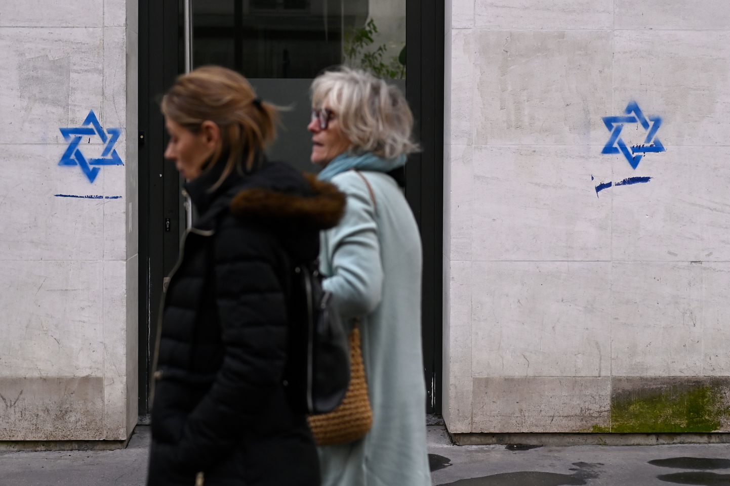 Naised mööduvad Pariisis maja seinale joonistatud Taaveti tähtedest.
