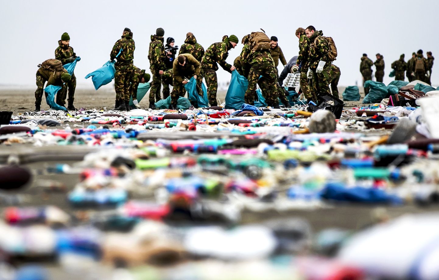 TOPSHOT - Netherlands' army soldiers take part in the cleaning of the coastline of Schiermonnikoog on January 4, 2019 in the Dutch Frisian Island, two days after some 270 containers tumbled from the Panama-registered MSC Zoe, one of the world's biggest cargo ships in rough weather. - The MSC Zoe, which was mostly carrying toys, furniture and auto parts, lost the containers late on Tuesday while battling a storm off the Frisian Islands, an archipelago off the northwestern Dutch coast also known as the Wadden Islands. (Photo by Remko de Waal / ANP / AFP) / Netherlands OUT