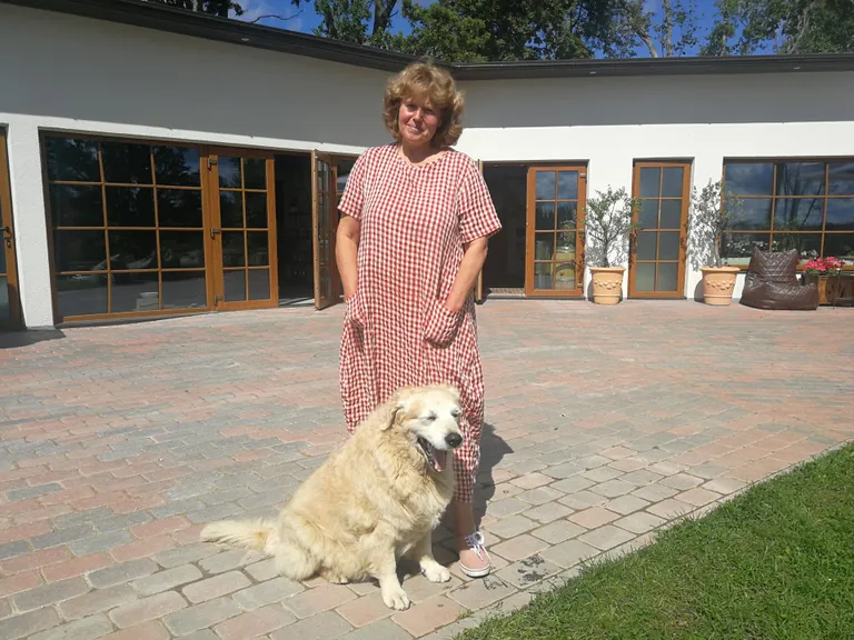 Murimäe perenaine Janika Ilves koos koer Muriga, kelle järgi on veinitalu nime saanud.