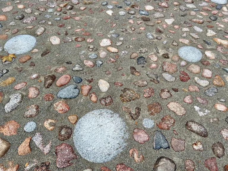 Круглые камни, оплаченные жертвователями, воткнуты вразброс между булыжниками в северо-восточном углу Ратушной площади Нарвы.
