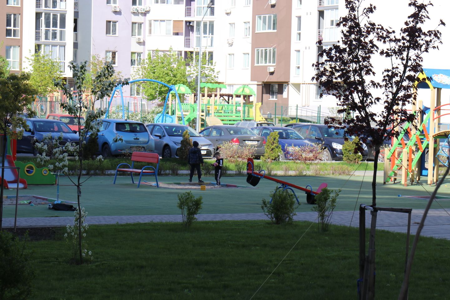 Буча, май 2022 года. Семьи начинают возвращаться в город, на детской площадке в жилом квартале играют дети.