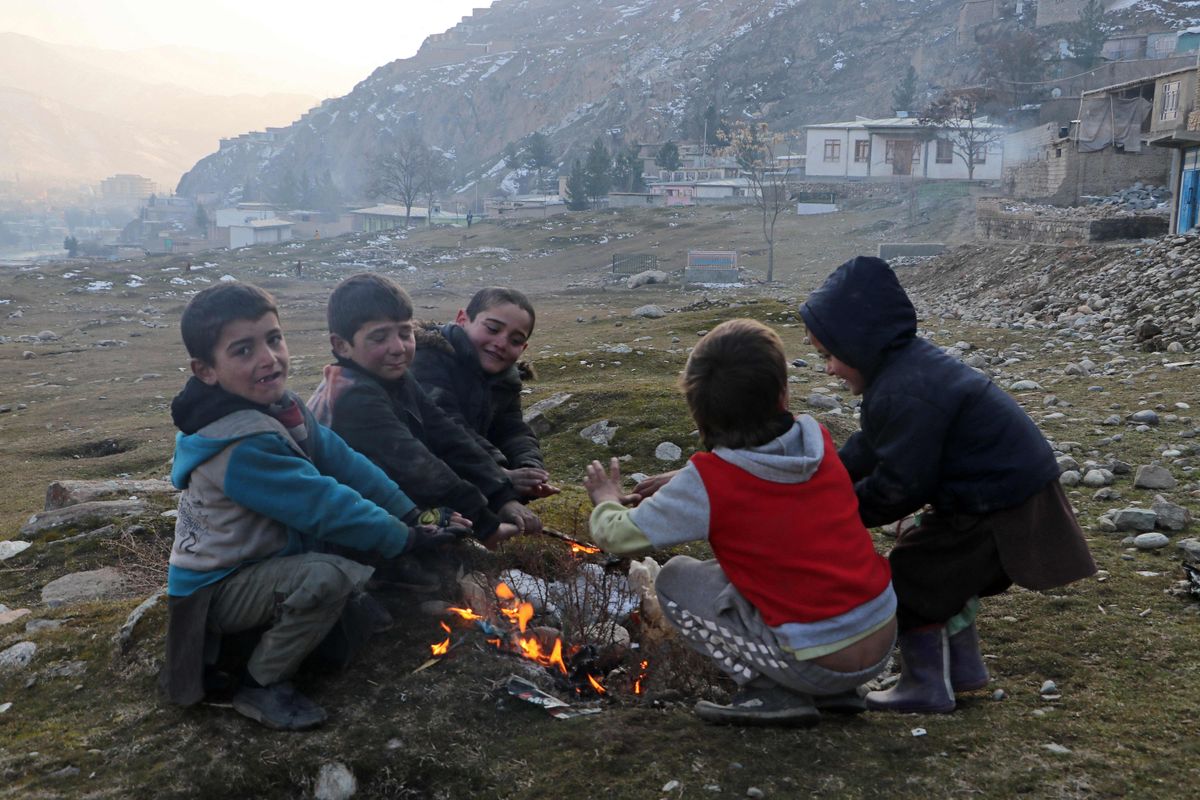 Афганские дети греются у огня. Провинция Бадахшан, Афганистан. Январь, 2023.