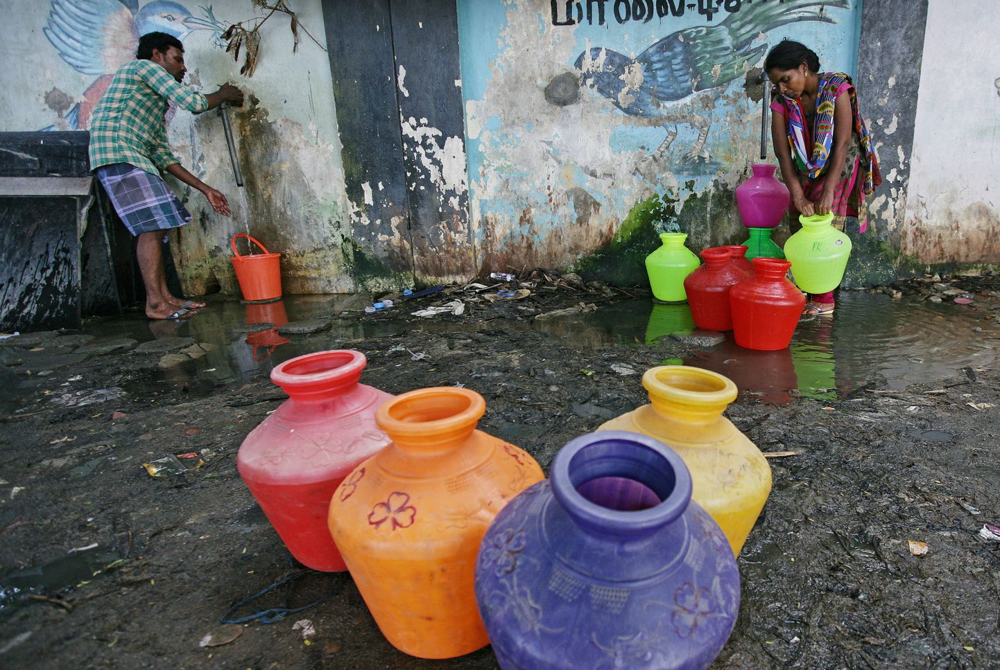 Iedzīvotāji Indijā uzpilda ūdens traukus.