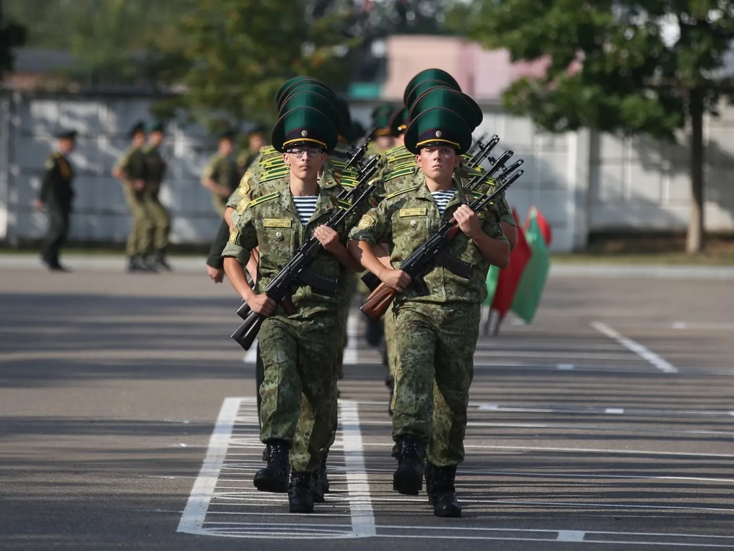 Белорусские пограничники с оружием в руках маршируют навстречу тому, кто пытается их получше разглядеть, август 2024 года, Беларусь.