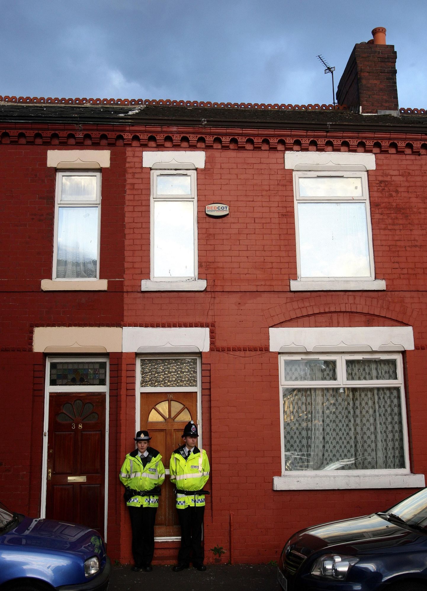 Briti politseinikud seismas ühe elamu ees Manchesteris pärast terrorivastast reidi Inglismaa loodeosas.