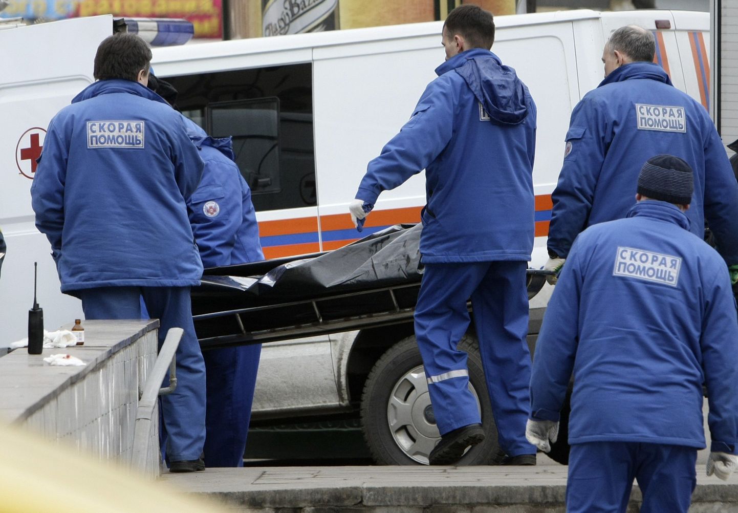 Vene eriolukordade ministeeriumi töötajad toimetavad surnukeha kiirabiautosse.