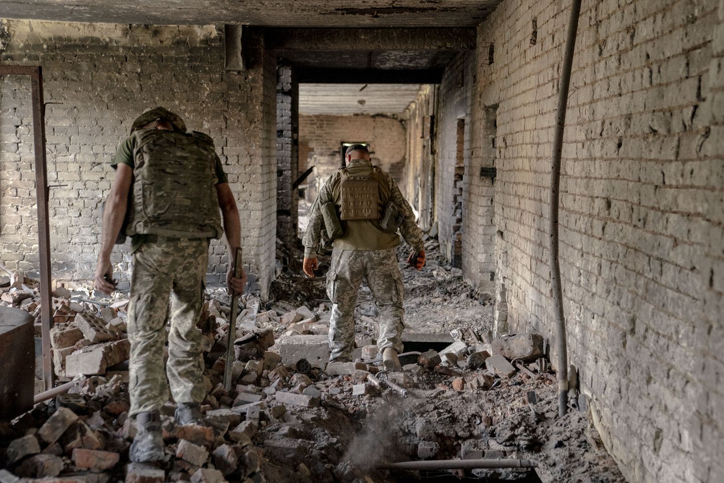 Ukraina sõdurid kõnnivad 3. septembril Ukrainas Harkivi lähedal hävitatud hoones.