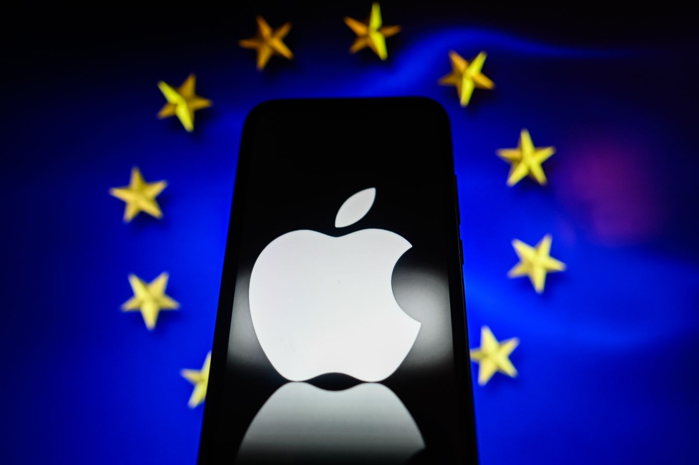 Apple'i logo nutitelefonis ELi lipu taustal. Euroopa Liit algatas Apple´i, Google´i emafirma Alphabeti ja Meta suhtes uurimise.