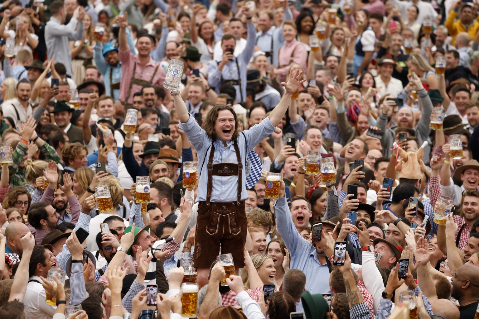 Külastaja juubeldab pärast õllekruusi tühjaksjoomist maailma suurima õllefestivali, 187. Oktoberfesti ametliku avamise ajal 17. septembril 2022 Saksamaal Münchenis.