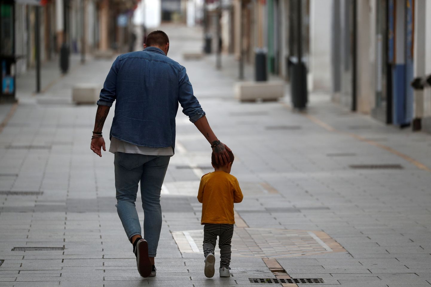 Vīrietis ar bērnu Spānijas ielās.