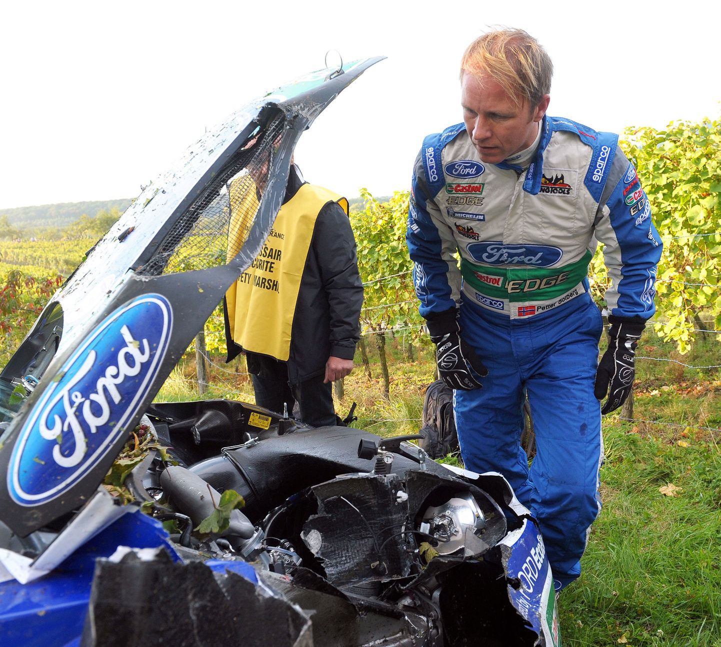 Petter Solberg Prantsusmaa rallil Ford Fiesta kapotialust uurimas