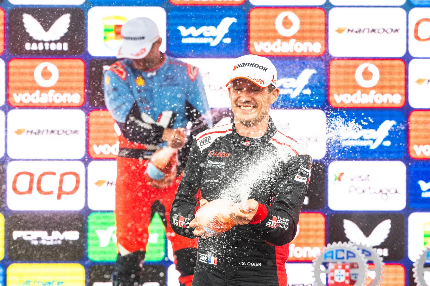 Sébastien Ogier Portugali MM-ralli poodiumitseremoonial šampanjat pritsimas.