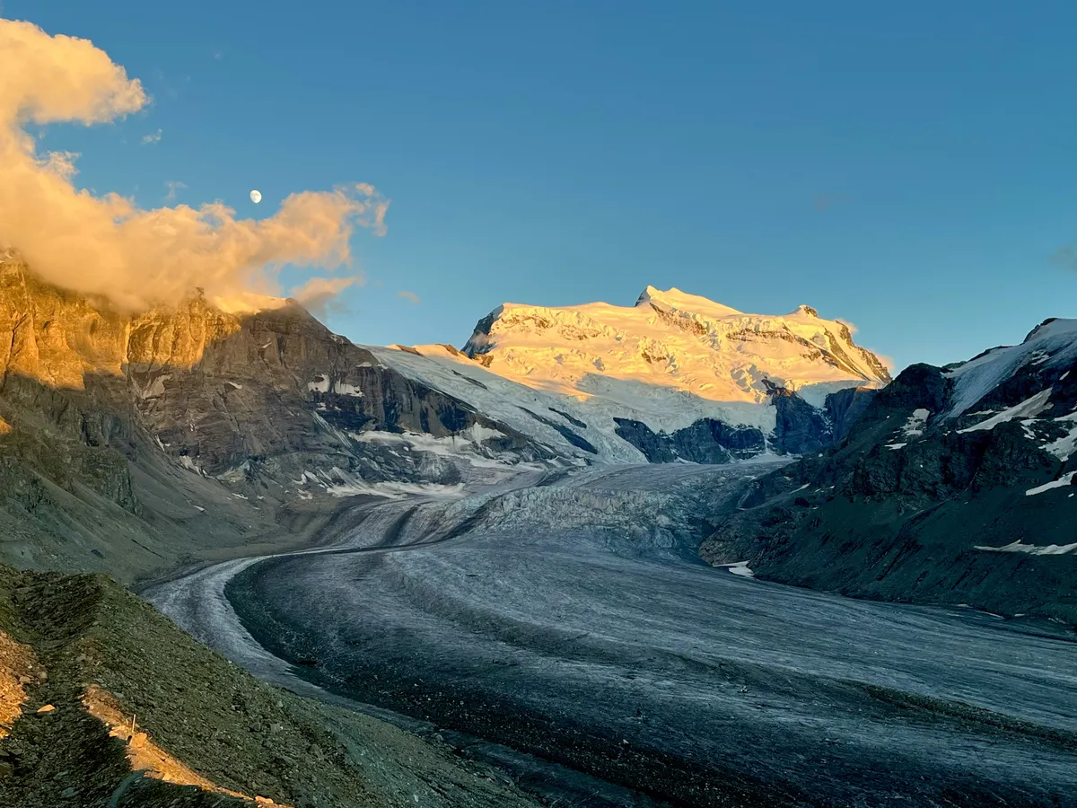 Grand Combin on piisavalt kõrge, et enamasti olla pilvevati sees peidus. Kuid õhtupäikese kuldses kumas läks taevas selgeks ning mäemassiiv näitas ennast kogu ilus. Vaade Cabane FXB à Panossière'i terrassilt.