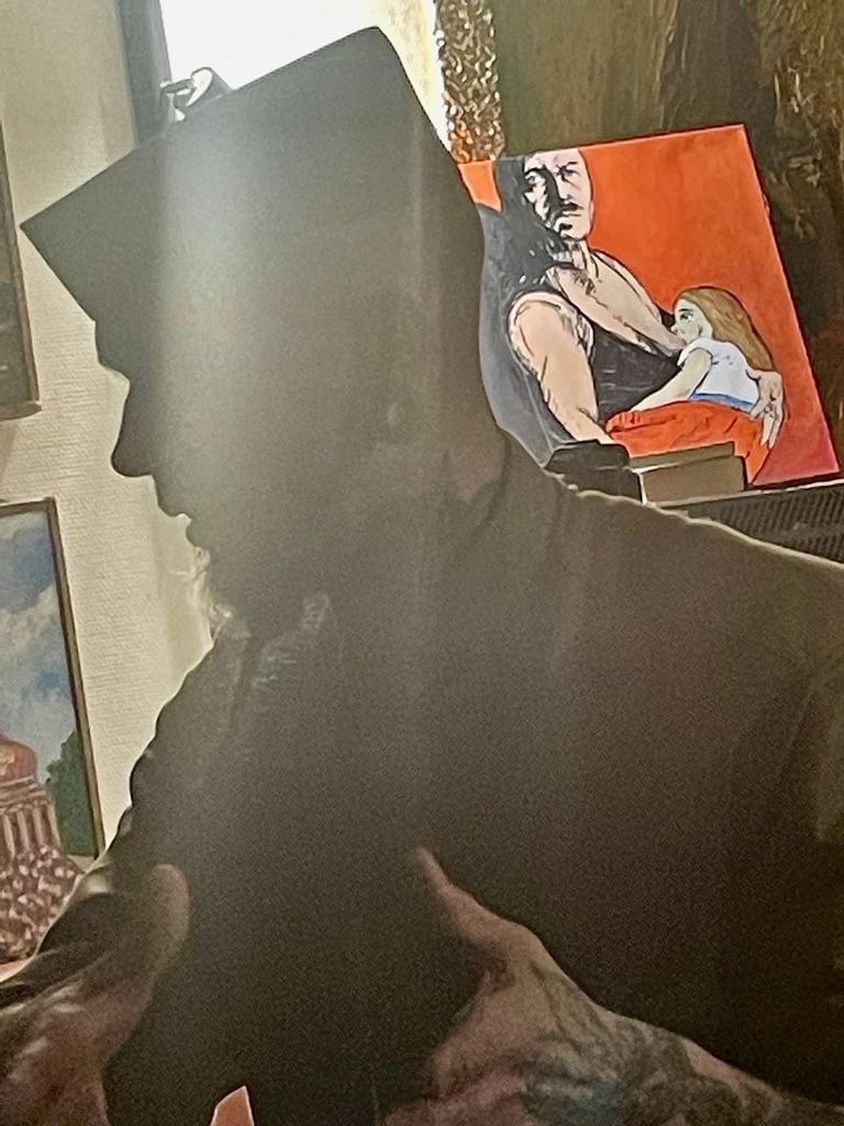 Вован Каштан в контражурном освещении на фоне провокационной живописи, по случаю обнаруженной в галерее