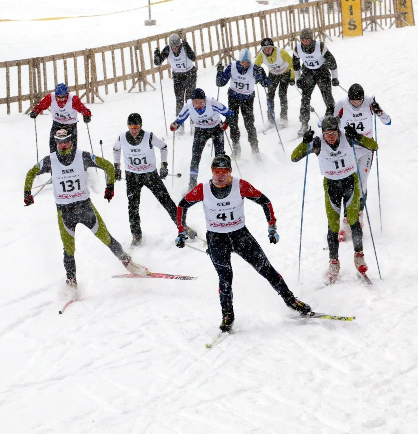 Noormeeste A- ja B-vanuseklassi teatesuusatamise avavahetuse sõitjad rühivad tuisku trotsides 3 km rajale.