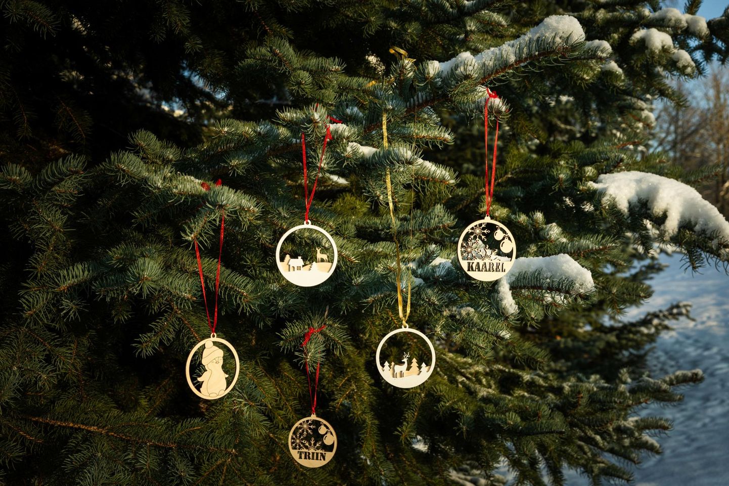 Kuusepuu võib dekoreerida ka õue ja pereliikmete nimeliste ehetega. Näiteks väikefirmast Artem Arbor saab tellida igaühele individuaalse vineerist «jõuluvisiitkaardi».
