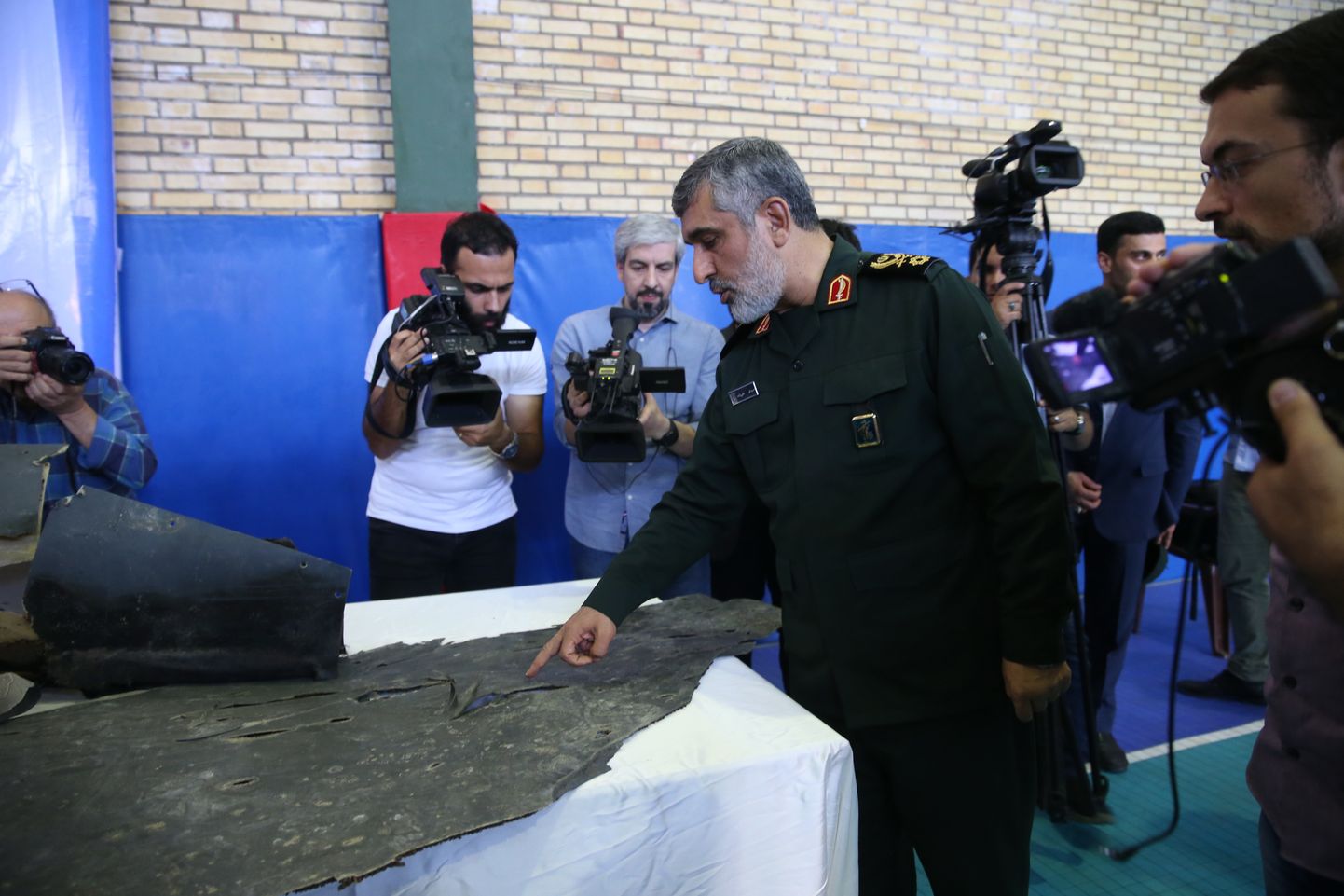 Iraani eliitväeosa revolutsioonikaardi õhujõudude komandör brigaadikindral Amir Ali Hajizadeh reedel Iraani riigitelevisiooni avaldatud fotodel allatulistatud USA luuredrooni tükke inspekteerimas.